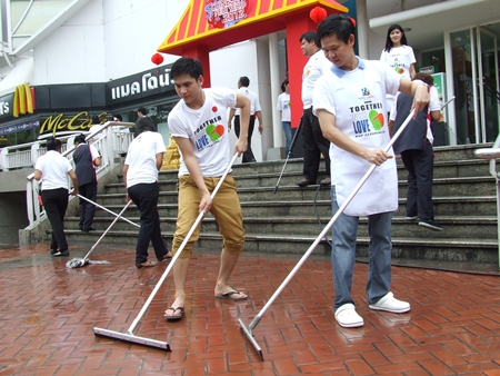 Royal Garden General Manager Somporn Naksuetrong (right) leads the early-morning cleanup effort.